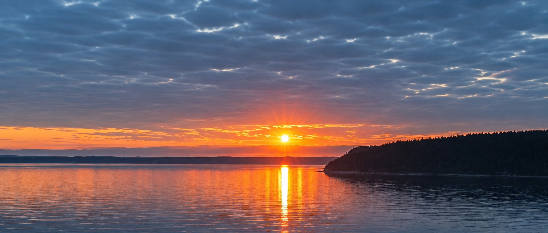 Sunset over water used as a North Country travel mood image